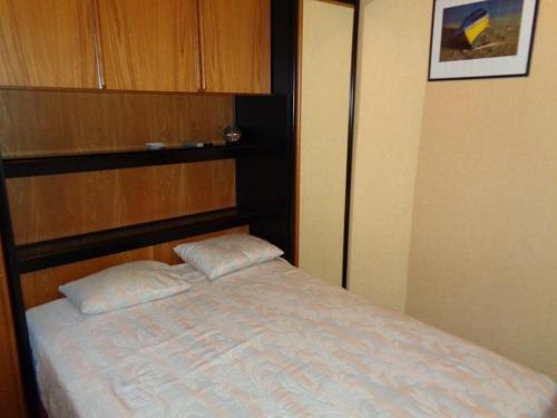 um quarto com uma cama com duas almofadas em Appartement Le Lavandou, 2 pièces, 4 personnes - FR-1-308-66 em Le Lavandou