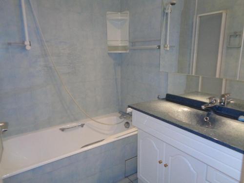 uma casa de banho com uma banheira e um lavatório e uma banheira em Appartement Le Lavandou, 2 pièces, 4 personnes - FR-1-308-66 em Le Lavandou