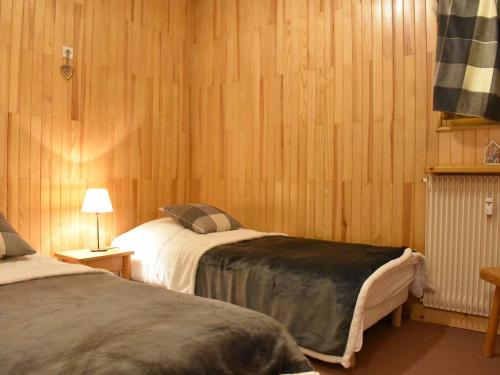 - 2 lits dans une chambre dotée de lambris dans l'établissement Charmant appartement 2 pièces 6 personnes, proche pistes et commerces - FR-1-180-349, à Méribel