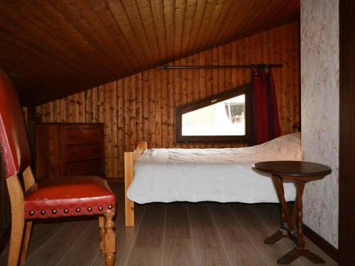 a bedroom with a bed and a chair and a window at Appartement Le Grand-Bornand, 2 pièces, 5 personnes - FR-1-241-167 in Le Grand-Bornand