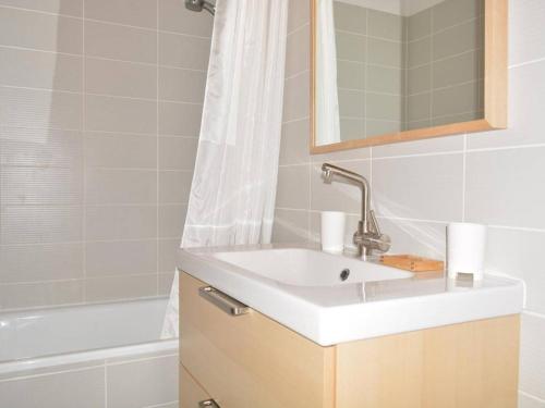 une salle de bain avec un lavabo et une baignoire dans l'établissement Appartement skis aux pieds 6 pers, balcon sud, garage, ménage inclus, 3* - FR-1-241-171, au Grand-Bornand