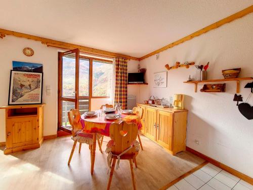 une cuisine avec une table et des chaises dans une pièce dans l'établissement Studio cosy avec balcon, au pied des pistes, accès direct et départ ski-in/ski-out! - FR-1-344-206, aux Menuires