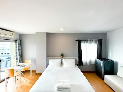 a bedroom with a large white bed and a table at The Island Resort in Bangkok