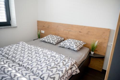 a bedroom with a bed with two pillows on it at Apartments Sunrise Banovci in Banovci