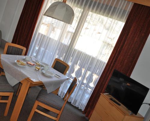 a dining room table with a view of a large window at Residence Anda in Pozza di Fassa