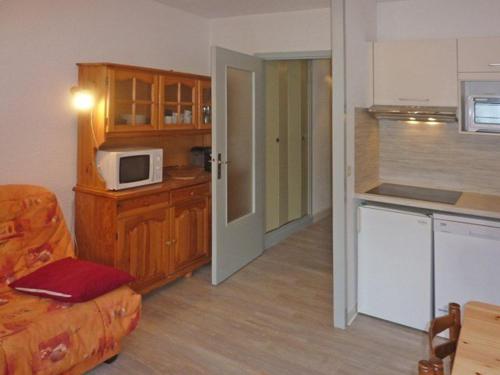 Il comprend une cuisine équipée d'un four micro-ondes et d'un canapé. dans l'établissement Studio 4 pers, skis aux pieds, terrasse sud-ouest, face patinoire - Les Orres - FR-1-322-284, aux Orres