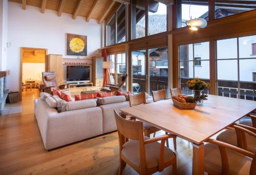 a living room with a table and a couch at Haus Malva in Zermatt
