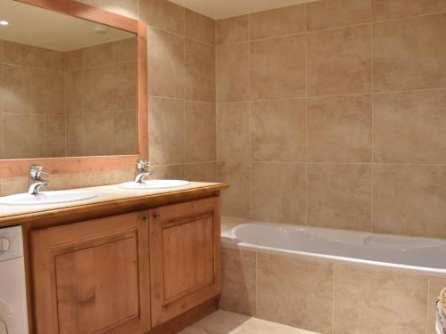 Appartement Méribel, 4 pièces, 8 personnes - FR-1-180-357 في Les Allues: حمام مع مغسلتين وحوض استحمام