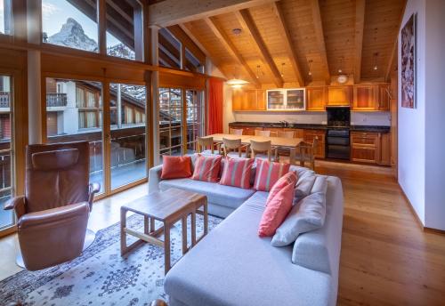 a living room with a couch and a table at Haus Malva in Zermatt