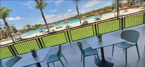 a balcony with tables and chairs and a view of the beach at Three Bedroom Apartment At The Blyde in Boschkop