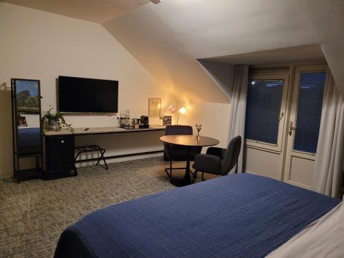 a bedroom with a bed and a desk with a computer at Boeren Maison in Wedde