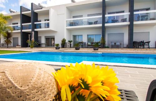 a villa with a swimming pool and a sunflower at By the sea, Algarve in Galé
