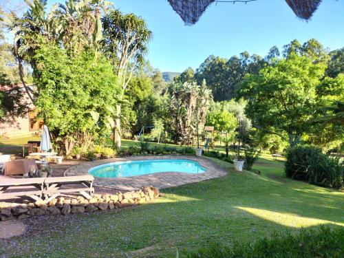 una piscina en un patio con un banco y árboles en ROCKABILLY RANCH Self-Catering Guest Units en Pietermaritzburg