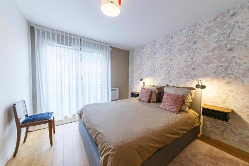 um quarto com uma cama grande e uma janela em Le B3 de Claire - Résidence La Montille em Le Mont-Dore