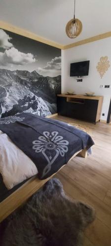 1 dormitorio con 1 cama con una pintura en la pared en Willa Hajnówka, en Zakopane