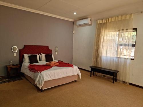sypialnia z dużym łóżkiem i oknem w obiekcie Guesthouse Serenity w mieście Hartbeespoort