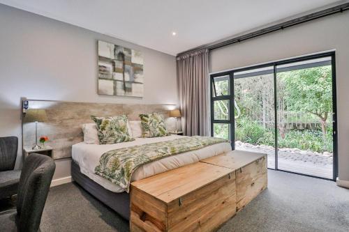 a bedroom with a bed and a large window at The Greens Guest House in Knysna