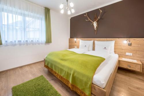 - une chambre avec un grand lit et une couverture verte dans l'établissement Haus zur Vogelweide App 1, à Dobbiaco
