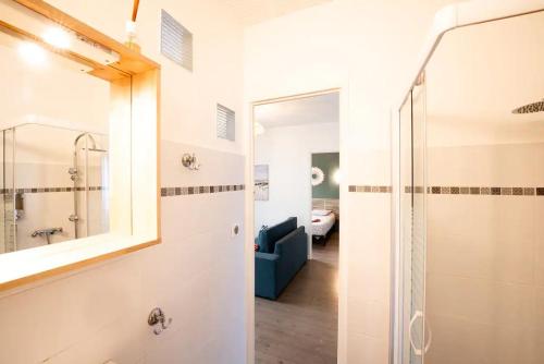 a bathroom with a walk in shower and a mirror at appartement n2 centre village, clim, parking gratuit in Aigues-Mortes