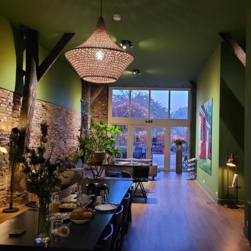 a dining room with a table and a large window at Boeren Maison in Wedde