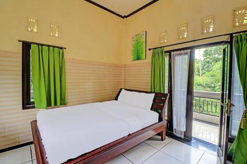 um quarto com uma cama com cortinas verdes e uma janela em OYO 91925 Ijo Eco Lodge Hotel em Kapal