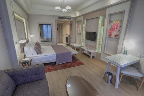 a bedroom with a bed and a couch and a table at The Green Park Ankara in Ankara