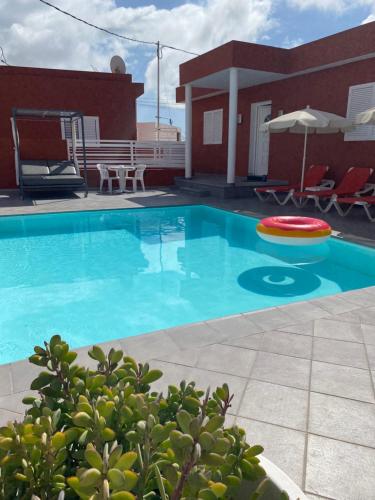 a large blue swimming pool with a frisbee next to a house at Sol y Mar El Salobre in Maspalomas