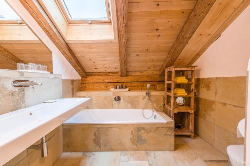 a bathroom with a tub and a wooden ceiling at Ferienwohnung Weitblick in Eggstätt