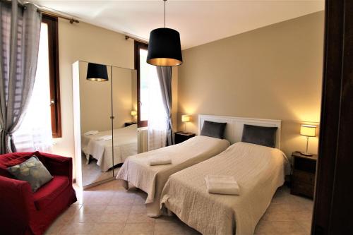 een slaapkamer met een bed, een stoel en een spiegel bij CENTRAL AND SPACIOUS APARTMENT in Venetië