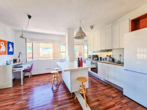 a large kitchen with white cabinets and wooden floors at Lujoso piso en Plaza de Toros in Murcia