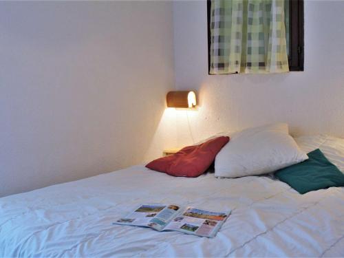 a bedroom with a bed with two pillows and a lamp at Appartement au pied des pistes avec balcon à Risoul - FR-1-330-146 in Risoul