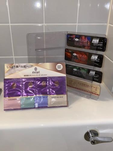 three packages of toothpaste sitting on top of a sink at Roppongi Plaza Hotel in Tokyo