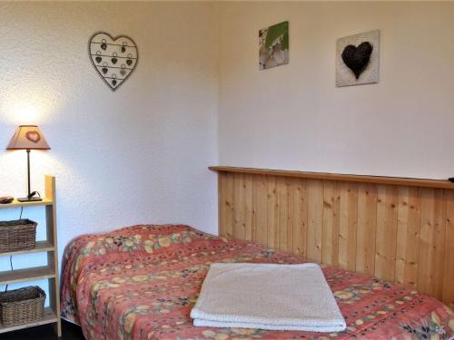 - une chambre avec un lit, une étagère et un cœur sur le mur dans l'établissement Studio cabine calme, 4 pers, pied des pistes - Risoul 1850 - FR-1-330-194, à Risoul