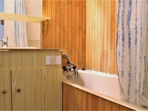 a bathroom with a bath tub and a shower curtain at Appartement Risoul, 2 pièces, 5 personnes - FR-1-330-143 in Risoul