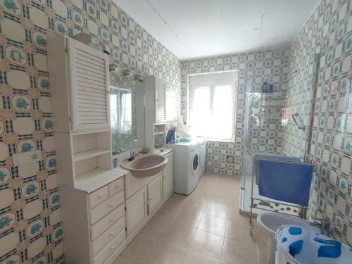 uma casa de banho com um lavatório e uma máquina de lavar roupa em Chalet de Tony Verde en plena naturaleza em Adanero