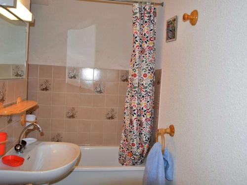 Un baño con lavabo y cortina de ducha. en Appartement cosy à Risoul 1850 - 4 couchages, proche remontées mécaniques et commerces - FR-1-330-220, en Risoul