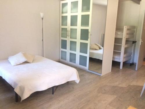 - une chambre avec un lit et un grand miroir dans l'établissement Appartement Risoul, 1 pièce, 4 personnes - FR-1-330-237, à Risoul