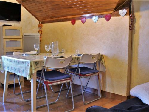 - une table avec des chaises et des verres à vin dans l'établissement Appartement pieds des pistes, 2 cabines, 4 personnes - Risoul 1850 - FR-1-330-173, à Risoul