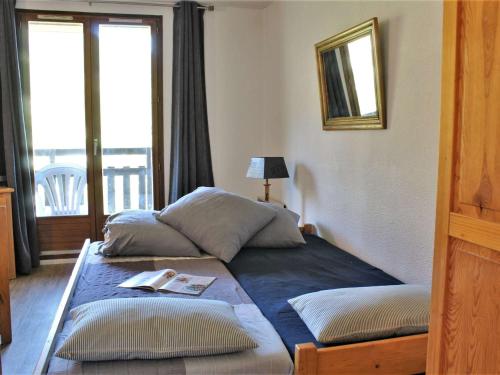 Cette chambre comprend 2 lits et un balcon. dans l'établissement Appartement 3 pièces à Risoul 1850 avec balcon et animaux admis - FR-1-330-241, à Risoul