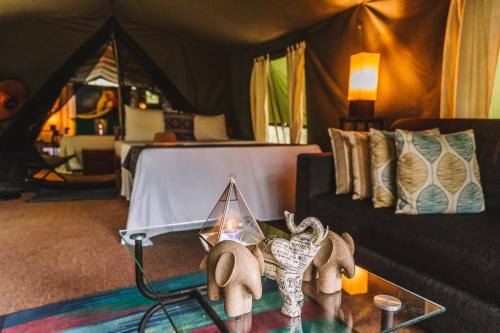 ein Wohnzimmer mit einem Zelt und einem Tisch mit einer Kerze in der Unterkunft Mahoora - Yala by Eco Team in Yala