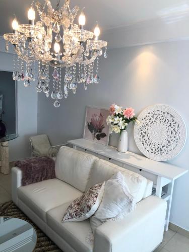 a living room with a couch and a chandelier at Sunny Rooms Mascot in Sydney