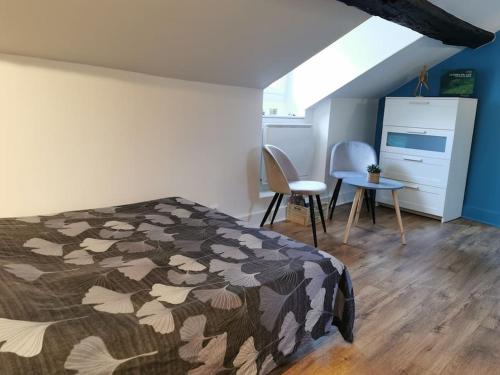 une chambre avec un lit, un bureau et des chaises dans l'établissement Studio sous les toits proche Paris et Versailles, à Chaville