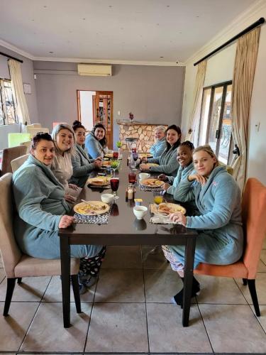 a group of people sitting at a table eating at Guesthouse Serenity in Hartbeespoort