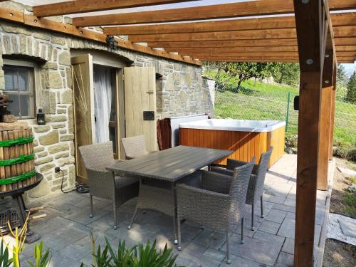 a patio with a table and chairs under a wooden pergola at Boti Hill Natural in Tihany