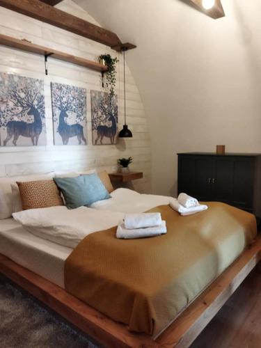 a bedroom with a large bed with two towels on it at Boti Hill Natural in Tihany