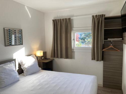 een slaapkamer met een wit bed en een raam bij Good Hôtel Marseille Aubagne - La Valentine in La Penne-sur-Huveaune