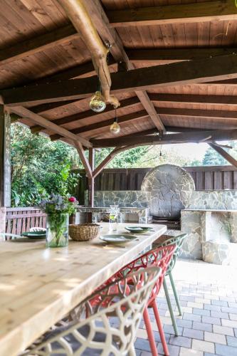 a patio with a table and chairs under a wooden roof at Zirbenholz Tiny House "Waldhauszeit" am See in Mücke
