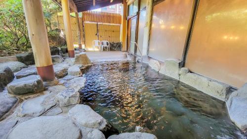 a koi pond in front of a building at Kamenoi Hotel Aso Park Resort in Aso