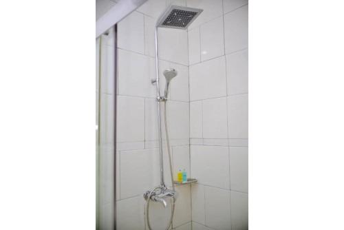 a shower with a shower head in a bathroom at Crystal Suites & Apartments in Kampala