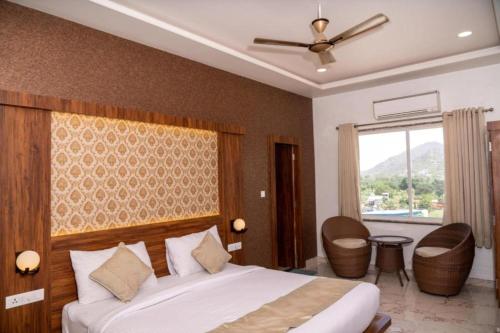 a bedroom with a large bed and a window at Hotel Agnija Udaipur in Udaipur